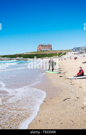 Balades les surfeurs sur la plage de Fistral hotspot surf à Newquay en Cornouailles. Banque D'Images