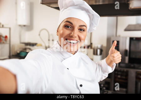 Portrait de femme chef professionnel portant uniforme blanc prenant en photo selfies au restaurant de cuisine Banque D'Images