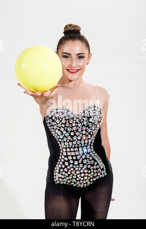 Un caucasian woman l'exercice de la gymnastique rythmique avec balle en studio isolé sur fond blanc. Banque D'Images