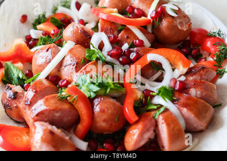 Saucisses frites avec des légumes sur un gâteau dans une assiette. Banque D'Images