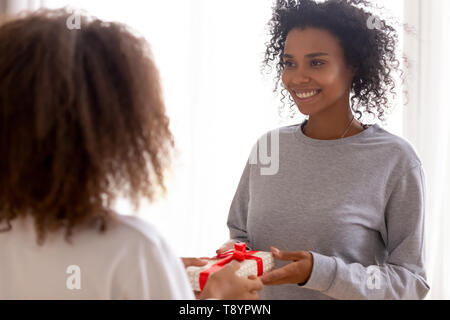 Happy African American mother la réception de cadeaux fille ado Banque D'Images