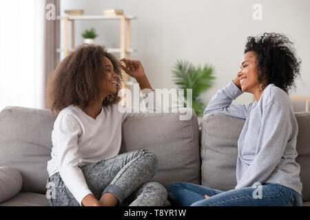 Happy African American mother and teen fille chatting at home Banque D'Images