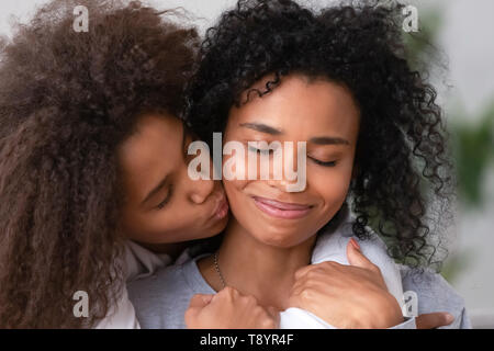 Close up African American teen fille embrassant smiling mother Banque D'Images