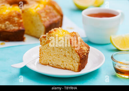 Gâteau bundt citron avec une tasse de thé. Fond bleu. Close up. Banque D'Images