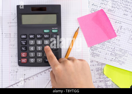 Doigt sur le bouton calculatrice mathématique au cours de leçon. Concept de l'école. Banque D'Images