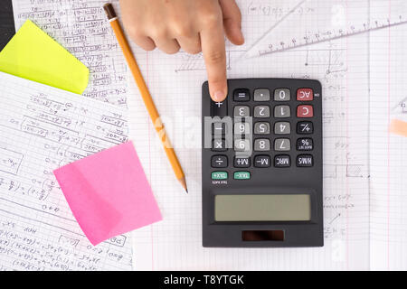 Doigt sur le bouton calculatrice mathématique au cours de leçon. Concept de l'école. Banque D'Images
