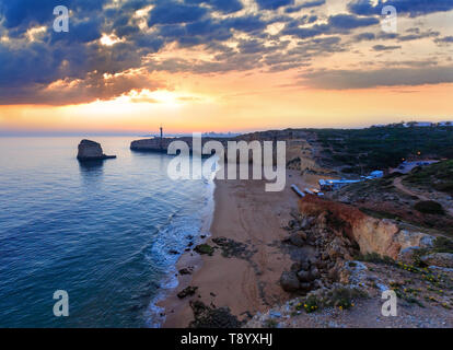 La côte de la mer avec vue sur le coucher de soleil phare de Ponta do autel. Vue ouest sur la plage de Praia da Afurada, Ferragudo, Lagoa, Algarve, Portugal. Banque D'Images