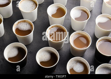 Beaucoup de gobelets en plastique avec de savoureux café aromatique sur table Banque D'Images