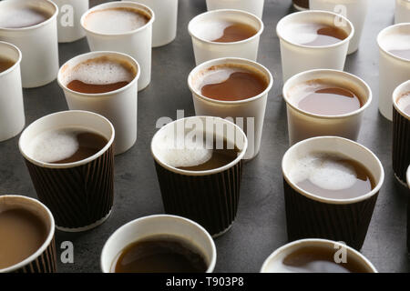 Beaucoup de gobelets en plastique avec de savoureux café aromatique sur table Banque D'Images