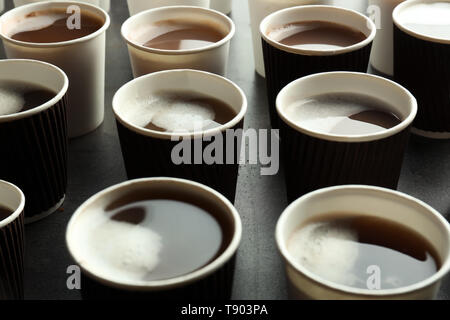 Beaucoup de gobelets en plastique avec de savoureux café aromatique sur table Banque D'Images