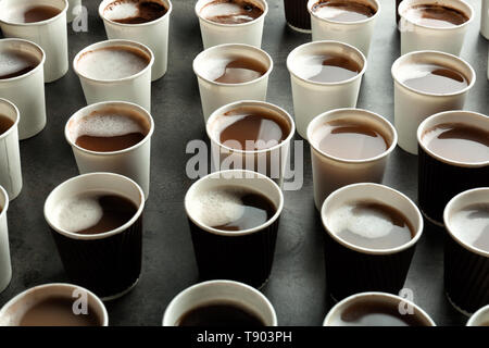 Beaucoup de gobelets en plastique avec de savoureux café aromatique sur table Banque D'Images