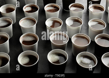 Beaucoup de gobelets en plastique avec de savoureux café aromatique sur table Banque D'Images