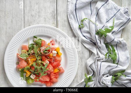 Plaque avec de délicieux sur salade de melon d'une table en bois blanc Banque D'Images