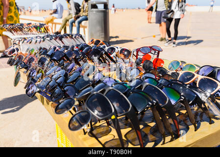 Valencia, Espagne - 12 mai 2019 : les immigrants illégaux de vendre de fausses lunettes et des souvenirs aux touristes sur la plage de Valence. Banque D'Images