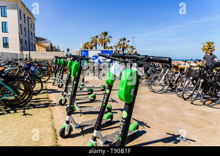 Valencia, Espagne - 12 mai 2019 : Des Vélos à louer pour les touristes et des scooters électriques de la chaux, garé sur la plage de Valence. Banque D'Images