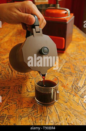 Man's hand pouring espresso aromatiques fraîchement préparé à partir de la cafetière Banque D'Images