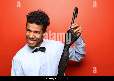 Portrait of happy afro-américain avec parapluie sur un fond de couleur Banque D'Images