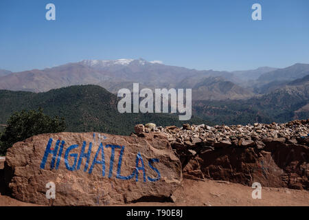 Haut Atlas outlook avec un signe peint bleu entre Marrakech et Ouarzazate, Maroc Banque D'Images