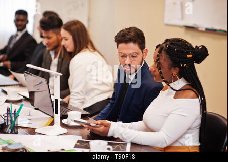 L'équipe entreprise multiraciale réunion d'adressage autour de table de conférence. Banque D'Images