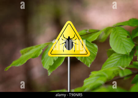 Insectes tiques panneau d'avertissement dans la nature de la forêt. La maladie de Lyme et la méningo-encéphalite à tiques émetteur. Banque D'Images