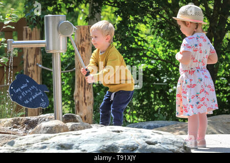 Kew Gardens, London, UK, 16 mai 2019. Jack a une jeune aller à la pompe à eau, tandis que son petit ami Ottilie est à regarder. Un nouveau jardin d'enfants est réglé pour s'ouvrir à la célèbre Kew Gardens. Le jardin est conçu autour des éléments que les plantes ont besoin pour croître : la terre, l'air, le soleil et l'eau. Il couvre la taille de 40 terrains de tennis, avec 18 000 100 plantes et arbres matures, et est appelé à être un refuge pour les jeunes à explorer et à jouer..REMARQUE : Permission accordée. Credit : Imageplotter/Alamy Live News Banque D'Images