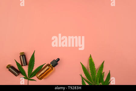 Diverses bouteilles avec gamme complète de Cannabidiol CBD huiles et feuilles de cannabis sur fond rose pastel Banque D'Images