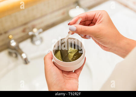 Fille avec une pincette sort eye patches à partir de la boîte de dialogue. Matin spa concept. Banque D'Images