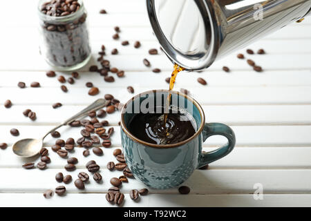 Verser du café chaud de Moka pot dans tasse sur la table Banque D'Images