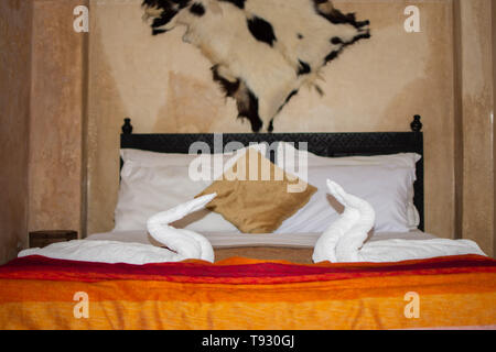 Deux cygnes faite de serviettes sur le lit dans la suite lune de miel chambre hôtel décoré pour un mariage ou seulement les personnes mariées. Banque D'Images