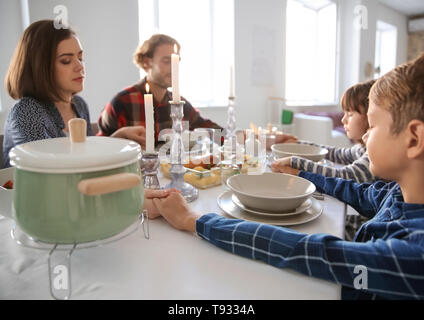 Prier en famille avant le repas à la maison Banque D'Images