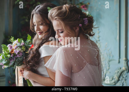 Mariée et demoiselles d'honneur. De belles jeunes femmes dans des robes et avec des bouquets de fleurs fraîches. Banque D'Images
