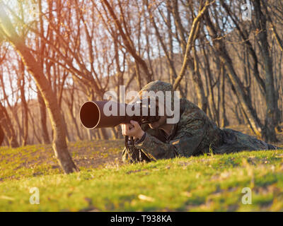 La faune, l'homme nature photographe en tenue de camouflage, prendre des photos de tournage Banque D'Images