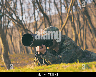 La faune, l'homme nature photographe en tenue de camouflage, prendre des photos de tournage Banque D'Images