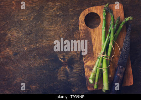 Bande d'asperges vertes fraîches sur fond de bois. Vue supérieure de la télévision. Espace libre pour votre texte. La tonalité de l'image. Banque D'Images