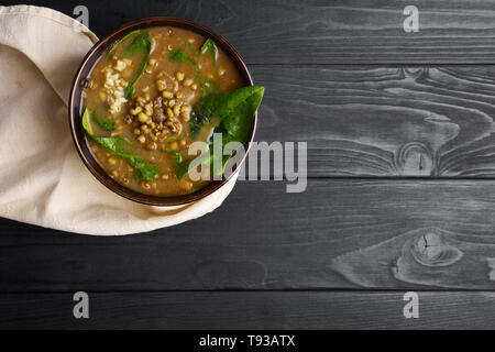 Mung Dhal avec épinards vert à table en bois noir. Moong Dal - la cuisine indienne, le curry. Plat végétarien avec zira et coriandre .Top view Copy Space Banque D'Images