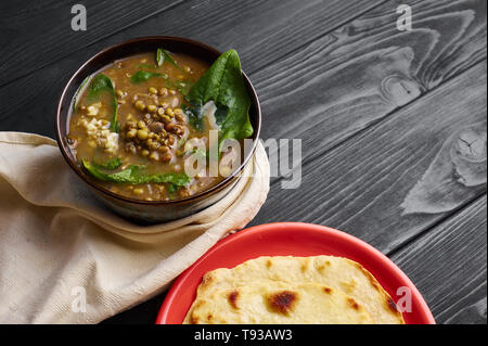 Mung Dhal avec épinards vert à table en bois noir. Moong Dal - la cuisine indienne, le curry. Plat végétarien avec chapati. Copy Space Banque D'Images