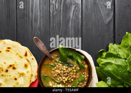 Mung Dhal avec épinards vert et Chapati à table en bois noir. Moong Dal - la cuisine indienne, le curry. Plat épicé végétarien.top view Copy Space Banque D'Images