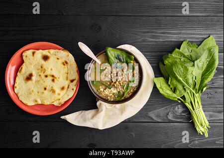 Mung Dhal avec épinards vert et Chapati à table en bois noir. Moong Dal - la cuisine indienne, le curry. Plat épicé végétarien.top view Copy Space Banque D'Images