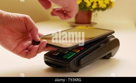 Payer avec une tablette sans fil sur la borne de carte de crédit. Banque D'Images