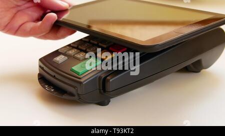 Payer avec une tablette sans fil sur la borne de carte de crédit. Banque D'Images