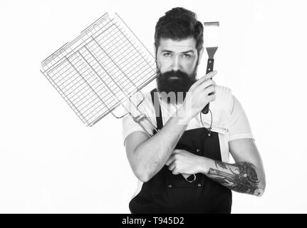 Hipster barbu porter un tablier pour barbecue. Le rôtissage et la cuisson des aliments. La cuisson des viandes conseils. Outils pour la viande à rôtir en plein air. Comment choisir la viande pour steak et barbecue. Menu barbecue. Pique-nique et barbecue. Banque D'Images