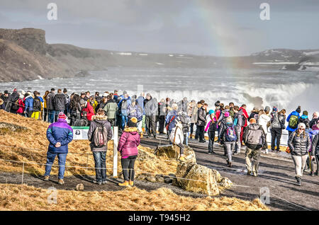 L'Islande, Gullfoss, Février 27, 2019 : des foules de touristes à la recherche à la célèbre cascade, adornd par un arc-en-ciel Banque D'Images