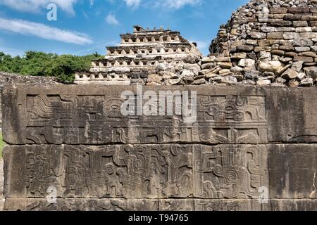 Panneaux en relief sculpté sur les murs du sud de balle avec la pyramide des niches derrière à la pre-Columbian complexe archéologique d'El Tajin dans Tajin, Veracruz, Mexique. El Tajín a prospéré à partir de 600 à 1200 EC, et pendant ce temps, de nombreux temples, palais, ballcourts, et les pyramides ont été construites par le peuple totonaque et est l'une des plus grandes et des plus importantes villes de l'ère classique de la Méso-Amérique. Banque D'Images