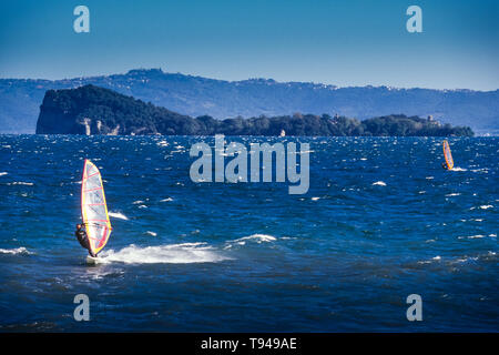 Surfers sur le lac de Bolsena (Italie) - La ville médiévale avec un château sur le lac de Bolsena, la région Latium, en Italie centrale Banque D'Images