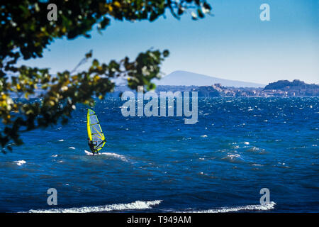 Surfers sur le lac de Bolsena (Italie) - La ville médiévale avec un château sur le lac de Bolsena, la région Latium, en Italie centrale Banque D'Images