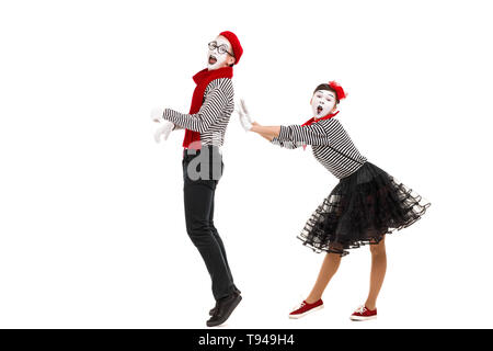 Surpris des mimes en chemises à rayures. L'homme et de la femme habillée en tant qu'acteurs de la pantomime theatre isolé sur fond blanc Banque D'Images