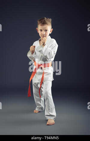 Portrait d'un enfant, pratiquer les arts martiaux kimono ceinture orange Banque D'Images