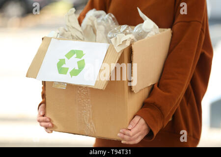 Young woman Holding boîte en carton avec des bouteilles en plastique à l'extérieur. Concept de recyclage Banque D'Images