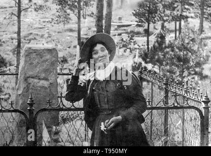 Calamity Jane, debout près de la tombe de Wild Bill Hickok, photogrpahed par J.A. Kumpf, 1903. Martha Jane Canary (1 mai 1852 - 1 août, 1903), mieux connu sous le nom de Calamity Jane, était un frontierswoman et professionnels du scoutisme. Elle a reçu peu ou pas d'éducation formelle et était analphabète. Elle a travaillé comme un lave-vaisselle, une cuisinière, une serveuse, un dance-hall, fille d'une infirmière et d'un bœuf, pilote de l'équipe. En 1874, elle a trouvé du travail en tant que scout à Fort Russell. Banque D'Images