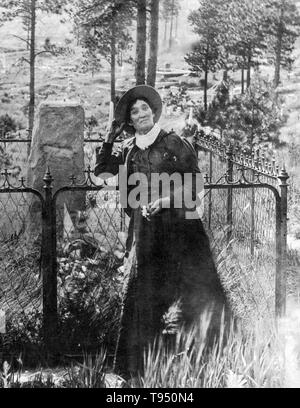 Calamity Jane, debout près de la tombe de Wild Bill Hickok, photogrpahed par J.A. Kumpf, 1903. Martha Jane Canary (1 mai 1852 - 1 août, 1903), mieux connu sous le nom de Calamity Jane, était un frontierswoman et professionnels du scoutisme. Elle a reçu peu ou pas d'éducation formelle et était analphabète. Elle a travaillé comme un lave-vaisselle, une cuisinière, une serveuse, un dance-hall, fille d'une infirmière et d'un bœuf, pilote de l'équipe. En 1874, elle a trouvé du travail en tant que scout à Fort Russell. Banque D'Images